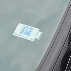 Parking ticket held in the clear clip on a car windscreen